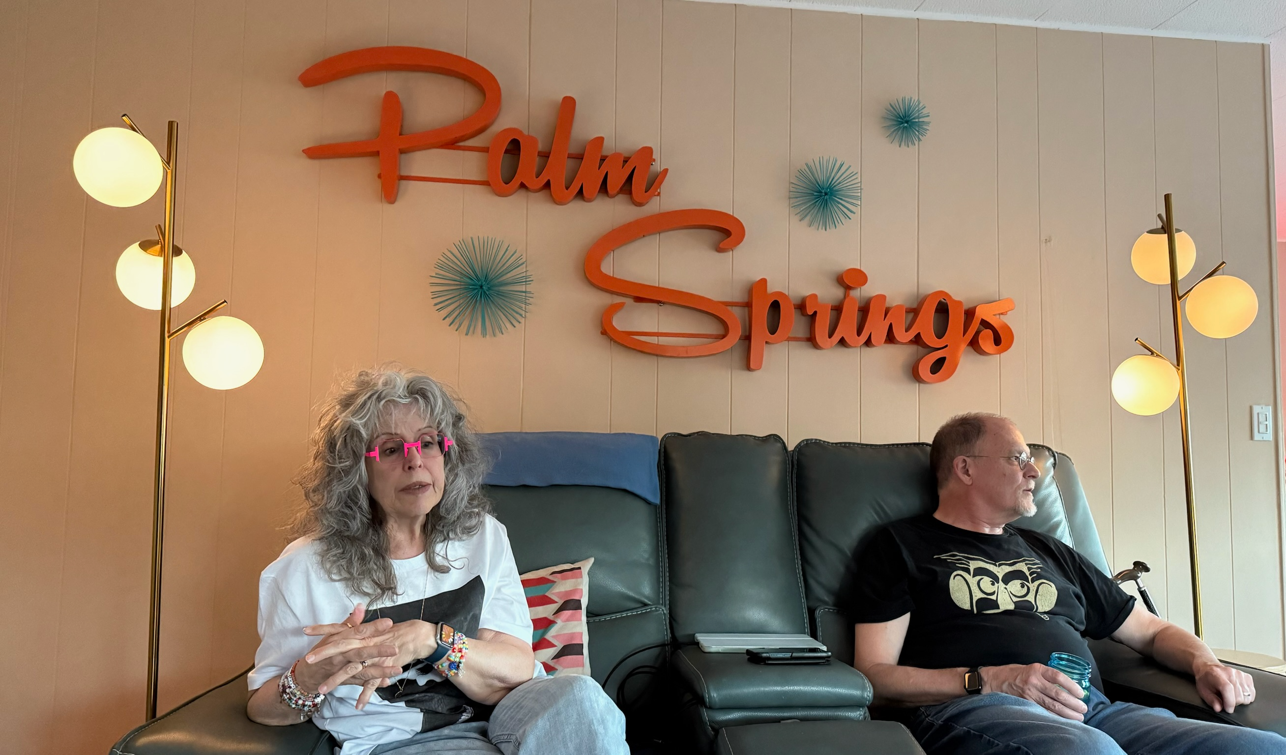 a view of Lisa and John in Todd's living room, in recliners with Palm Springs written on the wall behind us