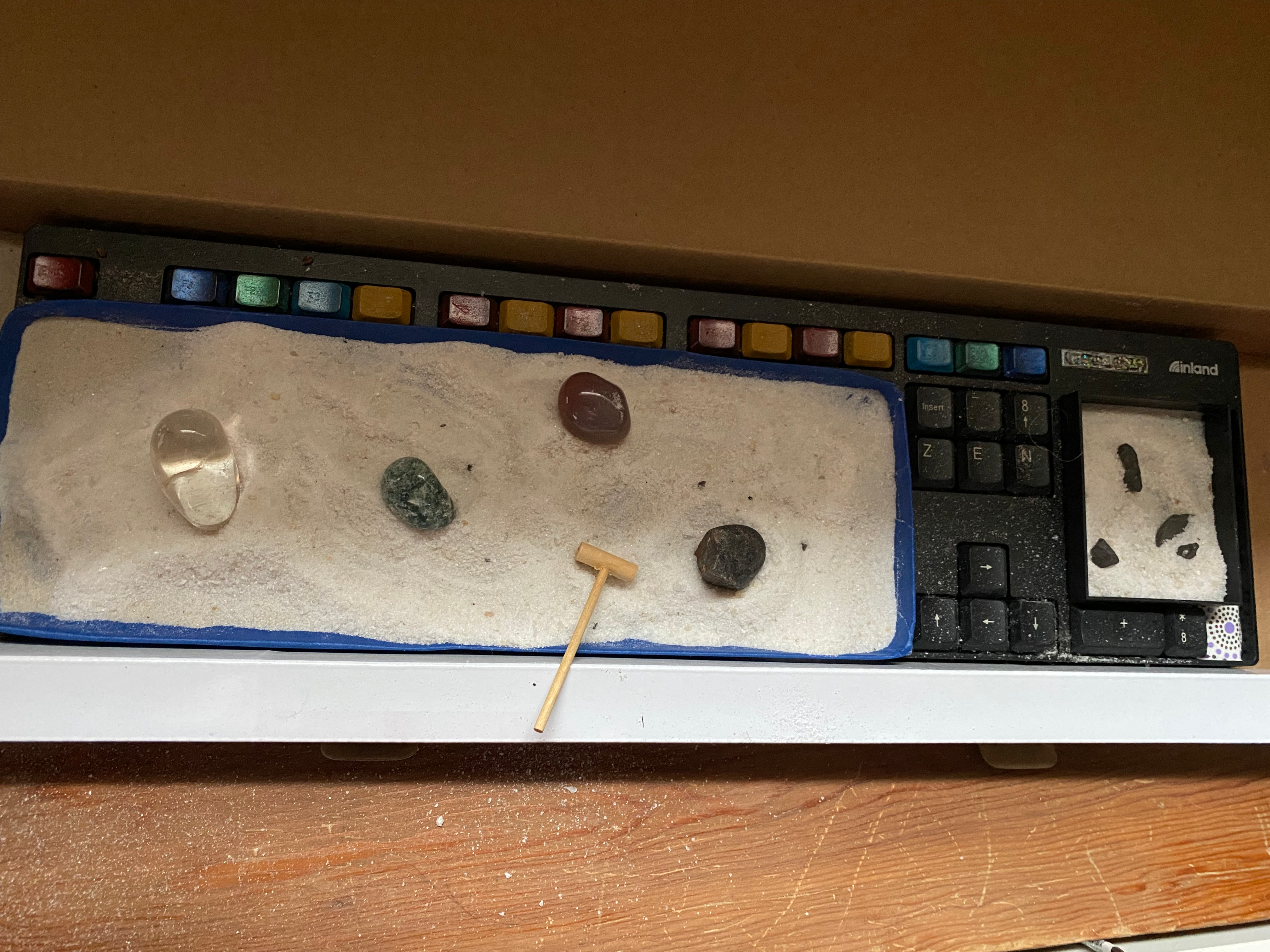 a computer keyboard turned into a mini Zen rock garden