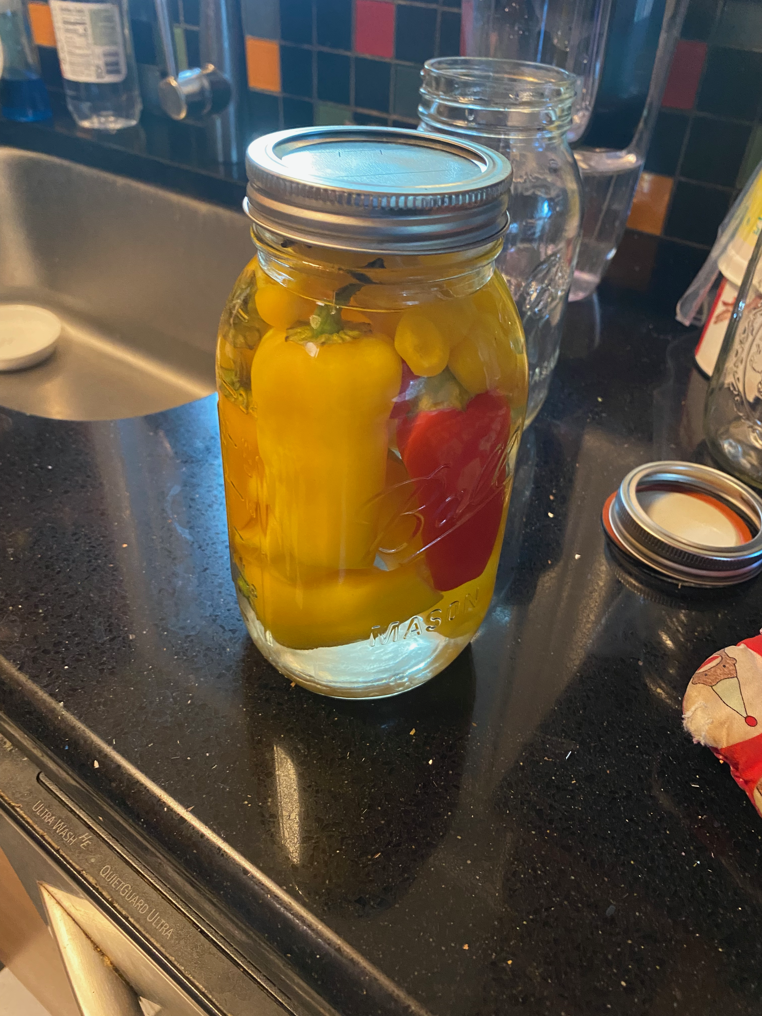 a mason jar of peppers being pickled